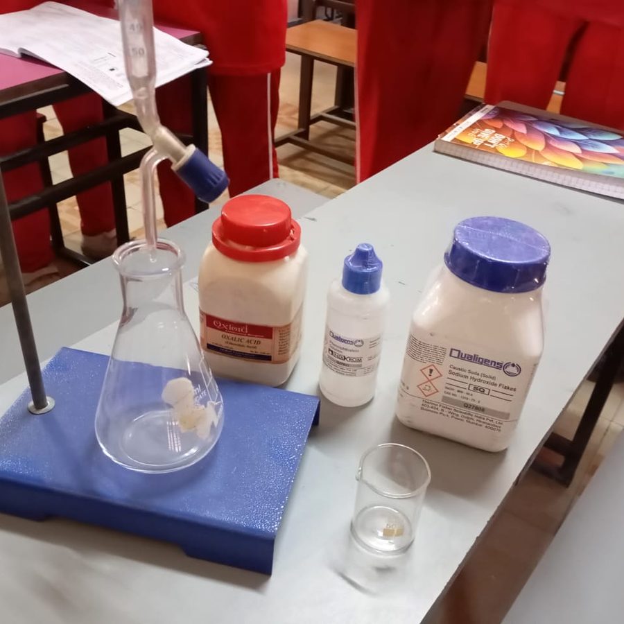 Chemistry glassware and reagent bottles on a lab bench